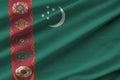 Turkmenistan flag with big folds waving close up under the studio light indoors. The official symbols and colors in banner