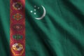 Turkmenistan flag with big folds waving close up under the studio light indoors. The official symbols and colors in