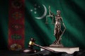 Turkmenistan flag with statue of lady justice, constitution and judge hammer on black drapery. Concept of judgement and