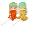 Turmeric and chili pepper powder in glass jar on white