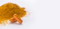 Turmeric or curcuma capsules, pile of orange powder on white