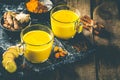 Turmeric golden milk and ingredients on wood background