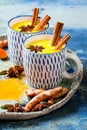 Turmeric golden milk latte with cinnamon sticks and honey. Detox, immune boosting, anti inflammatory healthy cozy drink. Royalty Free Stock Photo