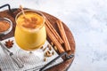 Turmeric golden milk latte with cinnamon sticks and honey. Healthy ayurvedic drink. Trendy Asian natural detox beverage with spice Royalty Free Stock Photo