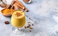 Turmeric golden milk latte with cinnamon sticks and honey. Healthy ayurvedic drink. Trendy Asian natural detox beverage with spice Royalty Free Stock Photo