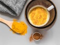 Turmeric latte with milk and cinnamon. Elixir of health and vivacity. Traditional healthy Indian detox drink. Grey background Royalty Free Stock Photo