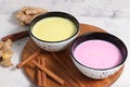 Turmeric latte and pink-golden milk for immunity, ginger and cinnamon on a gray table, helps fight viruses, has antioxidant