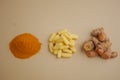 Turmeric powder, capsules, and fresh turmeric roots on table Royalty Free Stock Photo