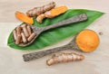 Turmeric powder; Turmeric capsules in a wooden spoon on the leaves and wooden. Turmeric root is herb for good health Royalty Free Stock Photo