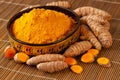 Turmeric powder and fresh roots in asian bowl closeup