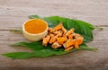 Turmeric powder and fresh turmeric on wooden background.