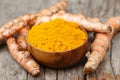 Turmeric powder in wooden bowls on wooden table