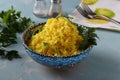 Turmeric rice garnish, popular vegetarian Indian dish on blue background. Close-up.