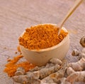 Turmeric roots powder in bowl wooden Royalty Free Stock Photo