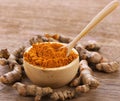 Turmeric roots powder in bowl wooden Royalty Free Stock Photo