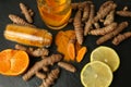 Turmeric roots, powder, sliced lemon and cup of tasty tea on black textured table, flat lay Royalty Free Stock Photo