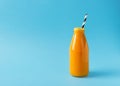 Turmeric smoothie in glass bottle with ingredients, turmeric powder on blue background Royalty Free Stock Photo