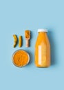 Turmeric smoothie in glass bottle with ingredients, turmeric powder on blue background Royalty Free Stock Photo