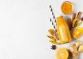 Turmeric smoothie in glass bottle with ingredients, turmeric powder, ginger and spice on white or light grey background Royalty Free Stock Photo