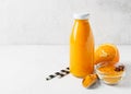 Turmeric smoothie in glass bottle with ingredients, turmeric powder, ginger and spice on white or light grey background Royalty Free Stock Photo