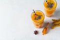 Turmeric smoothie in glass with ingredients, powder, ginger and spice on white or light grey background Royalty Free Stock Photo