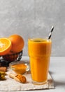 Turmeric smoothie in glass with ingredients, powder, ginger and spice on white or light grey background Royalty Free Stock Photo