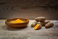 Turmeric, whole roots and powder against a rustic wooden background, healthy spice, anti-inflammatory and antioxidant, copy space