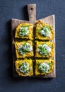 Turmeric, zucchini, mashed chickpeas tortilla with herbs served on a rustic cutting board on a dark background, top view. Delicio