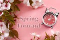 Turn clocks on hour ahead, star of daylight savings time change and reminder to spring forward concept with alarm clock on pink Royalty Free Stock Photo