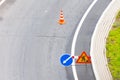 Turn left sign on the road. Warning signs and orange safety traffic cones on background. Direction of detour, roadworks. Road Royalty Free Stock Photo