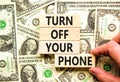 Turn off your phone symbol. Concept words Turn off your phone on wooden blocks. Beautiful background from dollar bills. Royalty Free Stock Photo