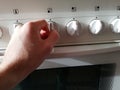 Turn on oven with dial, hand close up