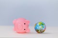 Turn over pink piggy bank and globe. Global financial crisis, copy space. Default and bankruptcy. Decrease in income Royalty Free Stock Photo