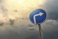 Turn right ahead sign, blue round roadside traffic signage, against the dramatic sky Royalty Free Stock Photo