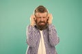 turn the sound down. unhappy hipster listening ebook. bearded man with loud sound in earphones. Royalty Free Stock Photo