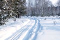 Turn of the winter road in the forest, deep snow and traces of passing cars Royalty Free Stock Photo