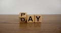 Turned a cube and changed the word `Pay` to `Day`. Beautiful wooden table. White background. Business concept Royalty Free Stock Photo