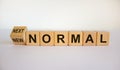 Turned a cube and changed the words `new normal` to `next normal`. Covid-19 postpandemic concept. Beautiful white background, Royalty Free Stock Photo