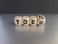 Turned cube and changes the acronym Toefl to Toeic, or vice versa. Beautiful black background,