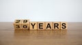 Turned cubes and changed the expression `29 years` to `30 years` or vice versa. Beautiful wooden table, white background. Busi