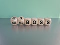 Turned cubes and changes the words small boss to big boss or vice versa. Beautiful gray table, blue background. Business concept, Royalty Free Stock Photo