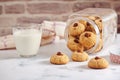 Turned jar with dropped out almond cookies, glass of milk