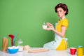 Turned photo of beautiful girl sit table hold jag with milk for homemade bread baking make lips pouted wear yellow Royalty Free Stock Photo