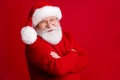 Turned photo of positive old man in santa claus headwear cross hands ready for holly jolly fairy newyear event wear