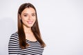 Turned portrait of lovely youth looking at camera with toothy smile wearing striped shirt over white background