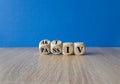 Turned wooden cubes and changes the German word passiv to aktiv. Beautiful wooden table blue background