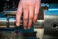 Turner hand setting workpiece in 3-jaw chuck of small metalworking lathe Royalty Free Stock Photo