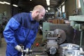 Turner makes a machining of steel part using turning lathe.