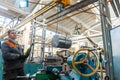 Turner worker manages the metalworking process of mechanical cutting on a lathe