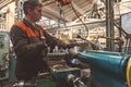 Turner worker manages the metalworking process of mechanical cutting on a lathe